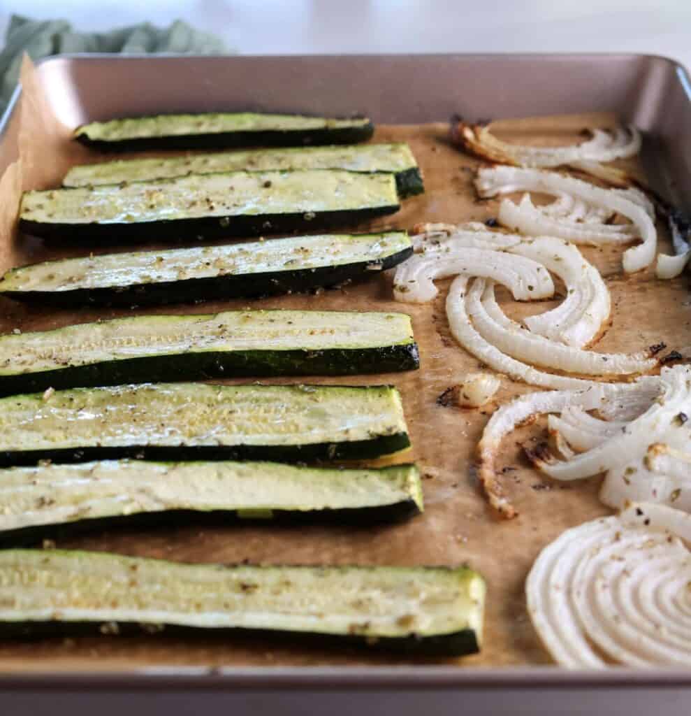 The roasted zucchini and onions on the baking sheet right out of the oven.