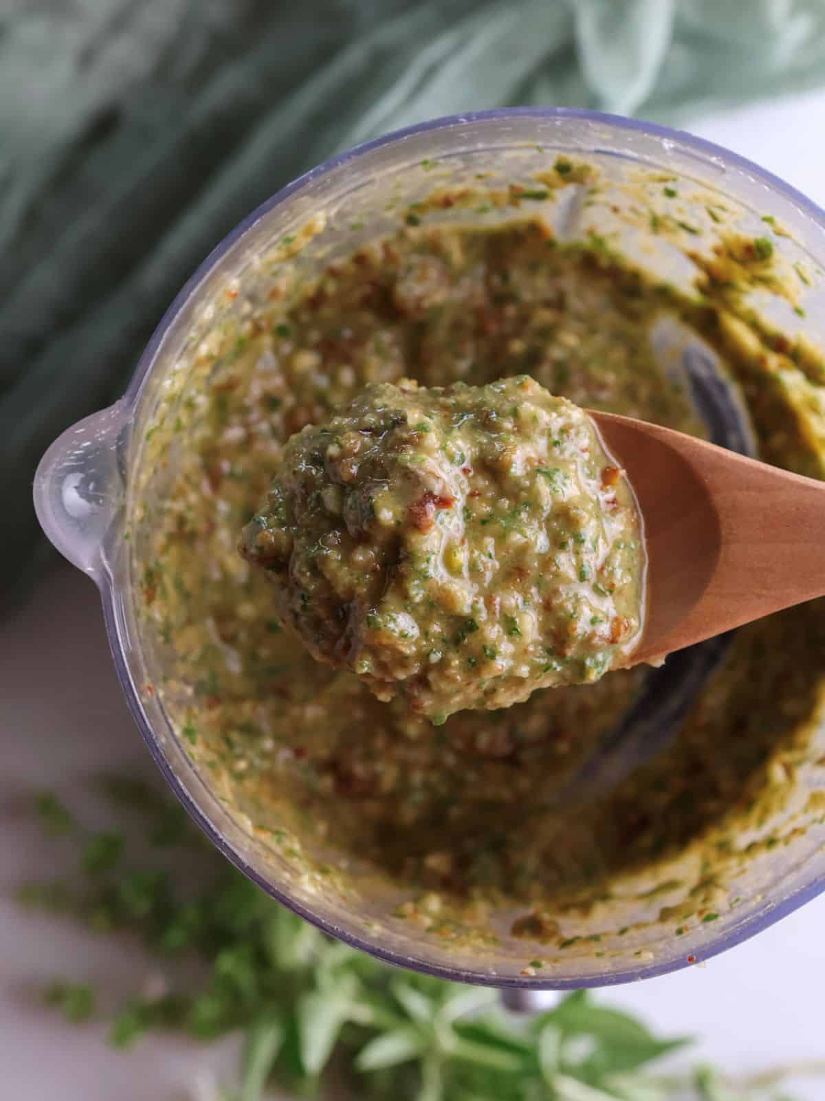 The sun dried tomato pesto on a spoon