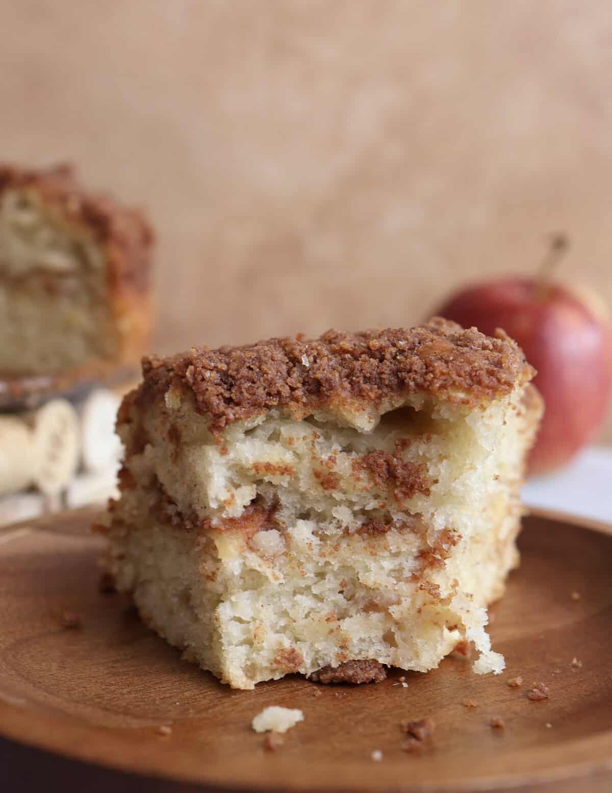 Apple coffee cake with bites taken out, showing the cinnamon sugar apple center. 