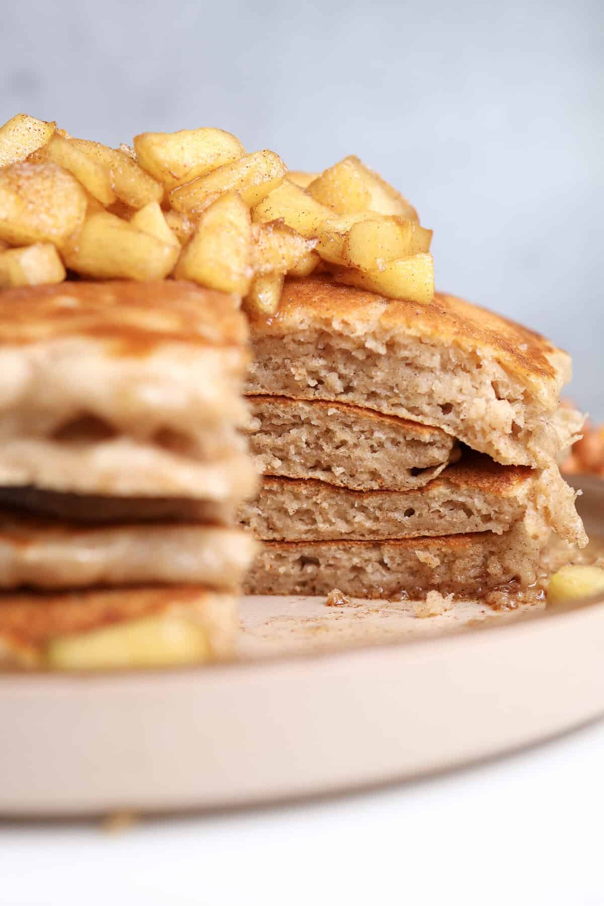Up close of a stack of cottage cheese pancakes cut into, showing the soft and fluffy center of the pancakes. 