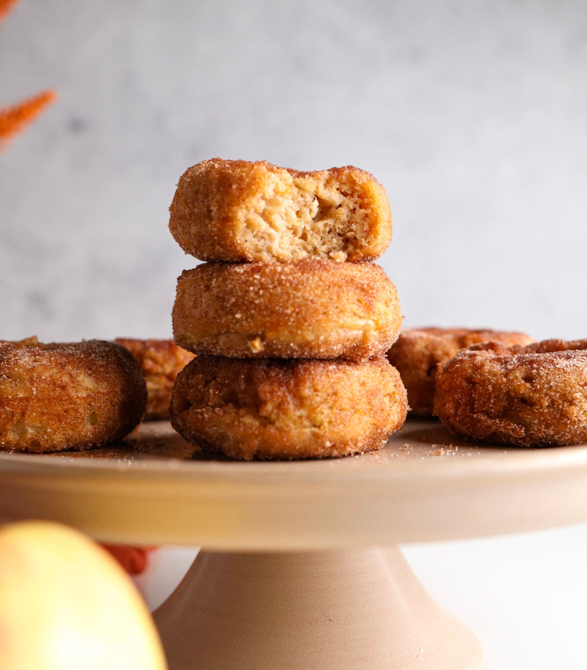 Apple baked donuts with cinnamon sugar stacked on each other.