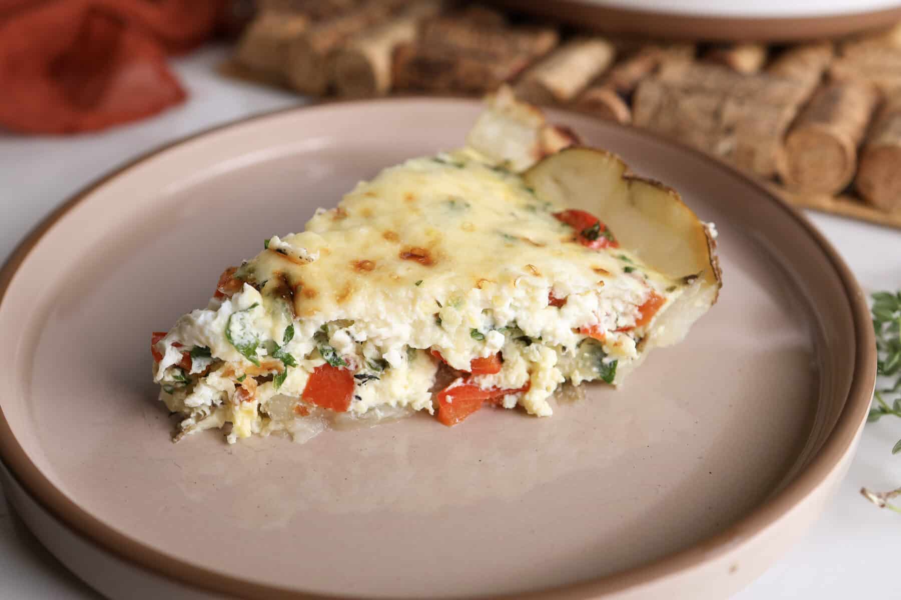 A slice of the potato crust quiche with kale and feta on a plate.