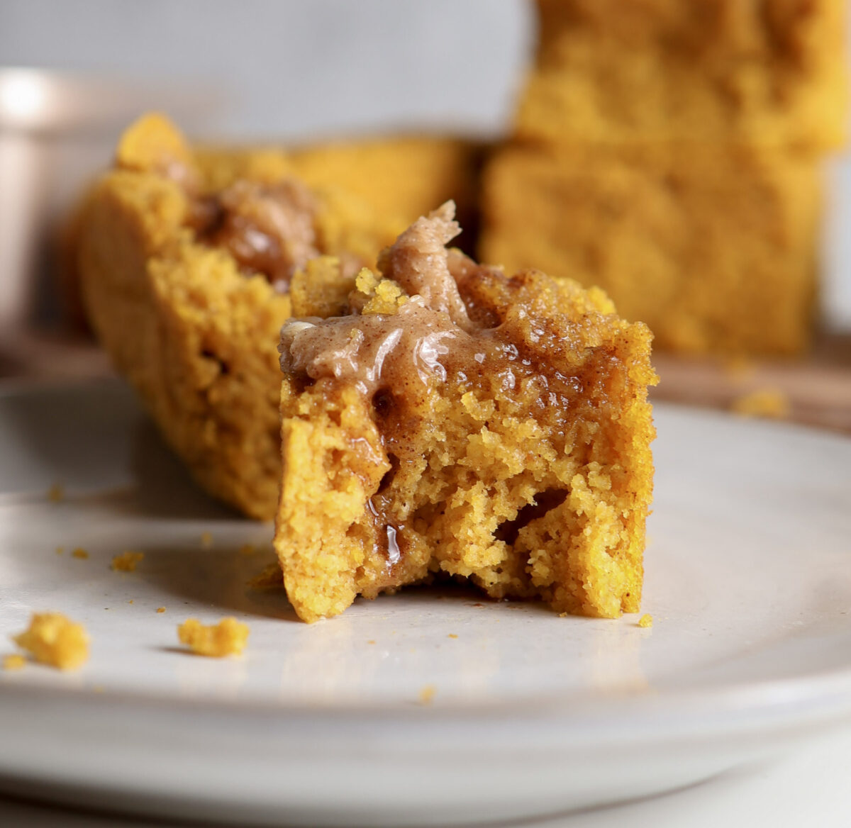 Up close shot of pumpkin cornbread slice with honey cinnamon butter melting in. 
