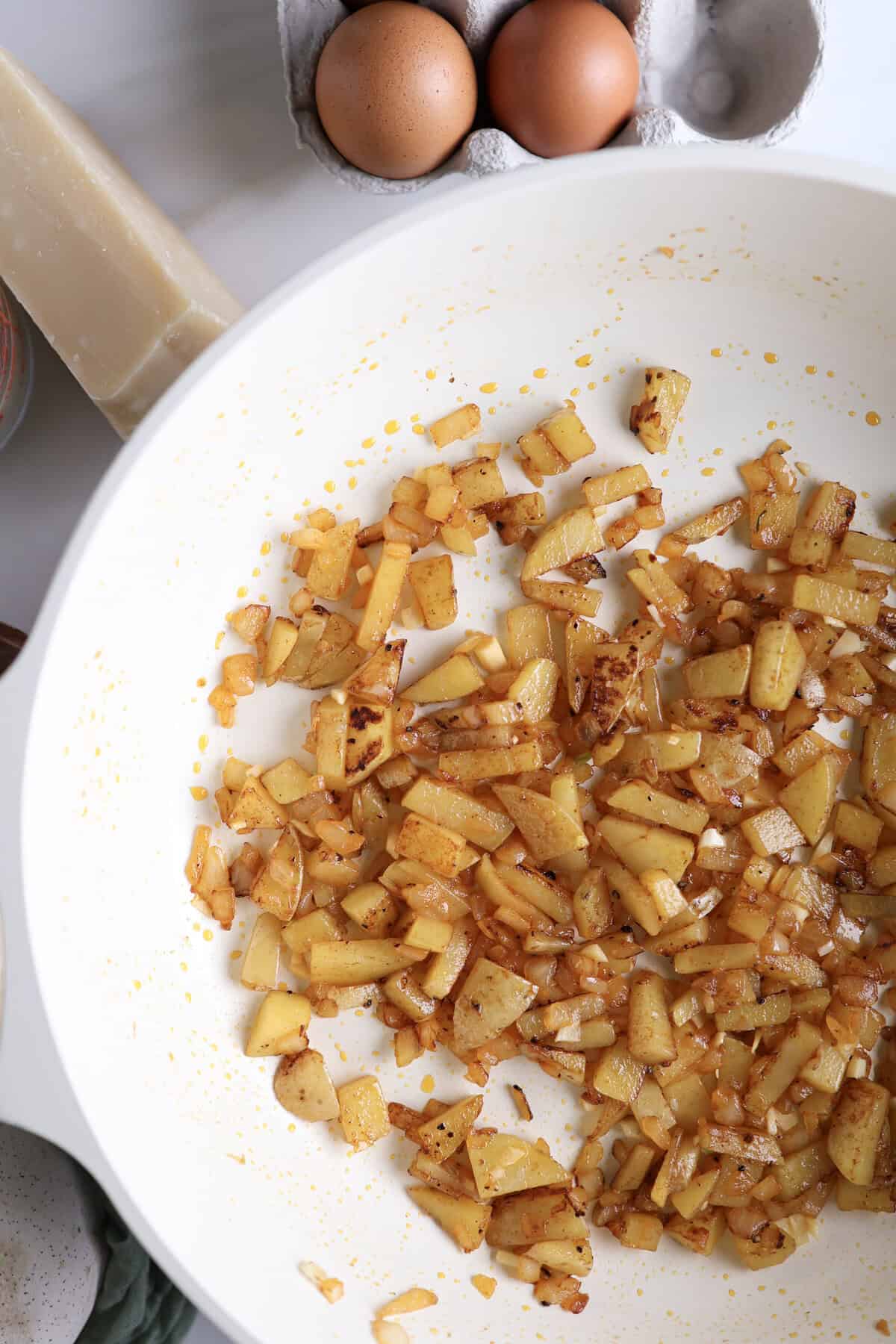 Up close shot of the potatoes being sauteed in the skillet for the protein egg bites. 