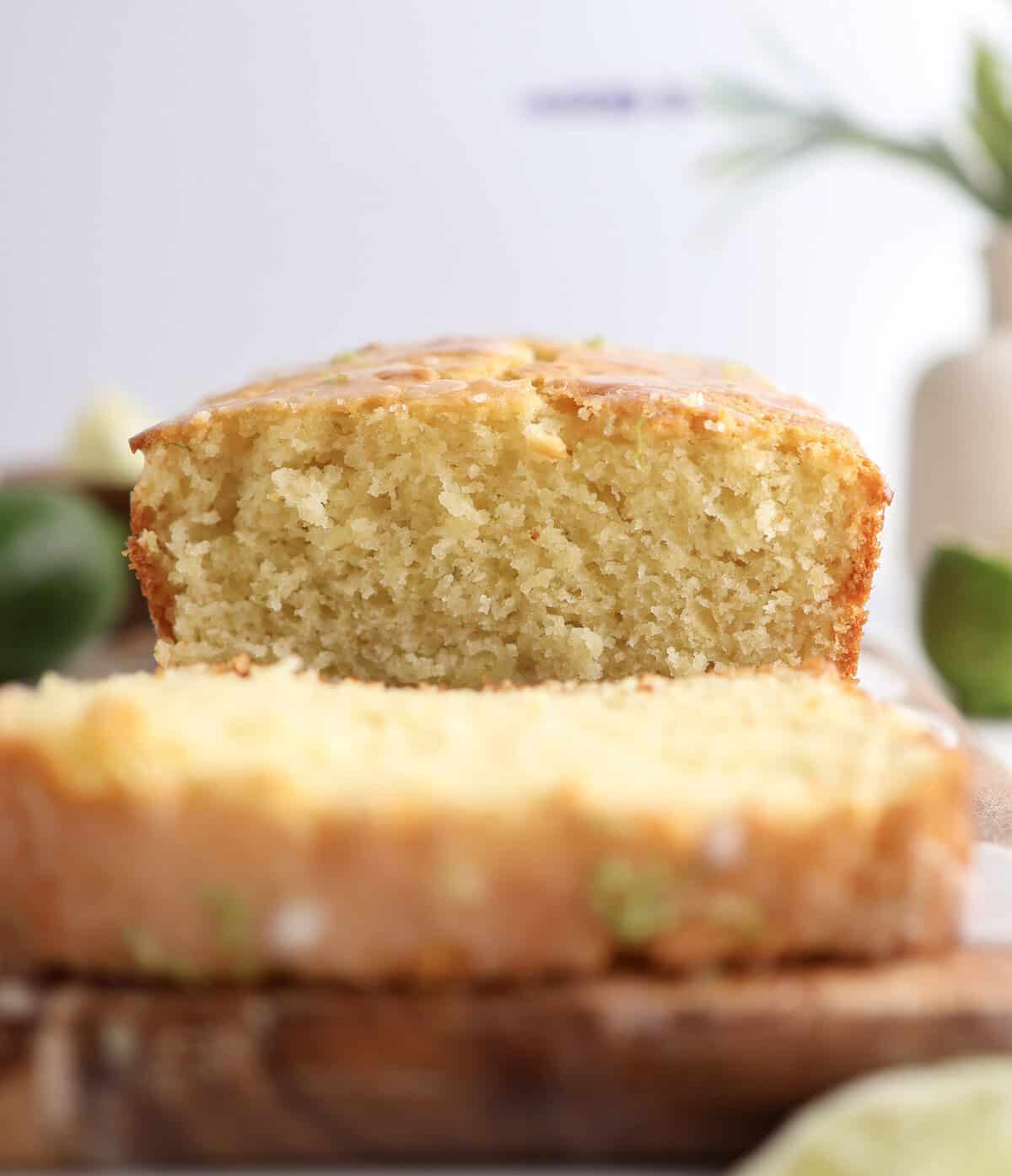 Up close shot of the lime loaf cake sliced into on a cutting board.