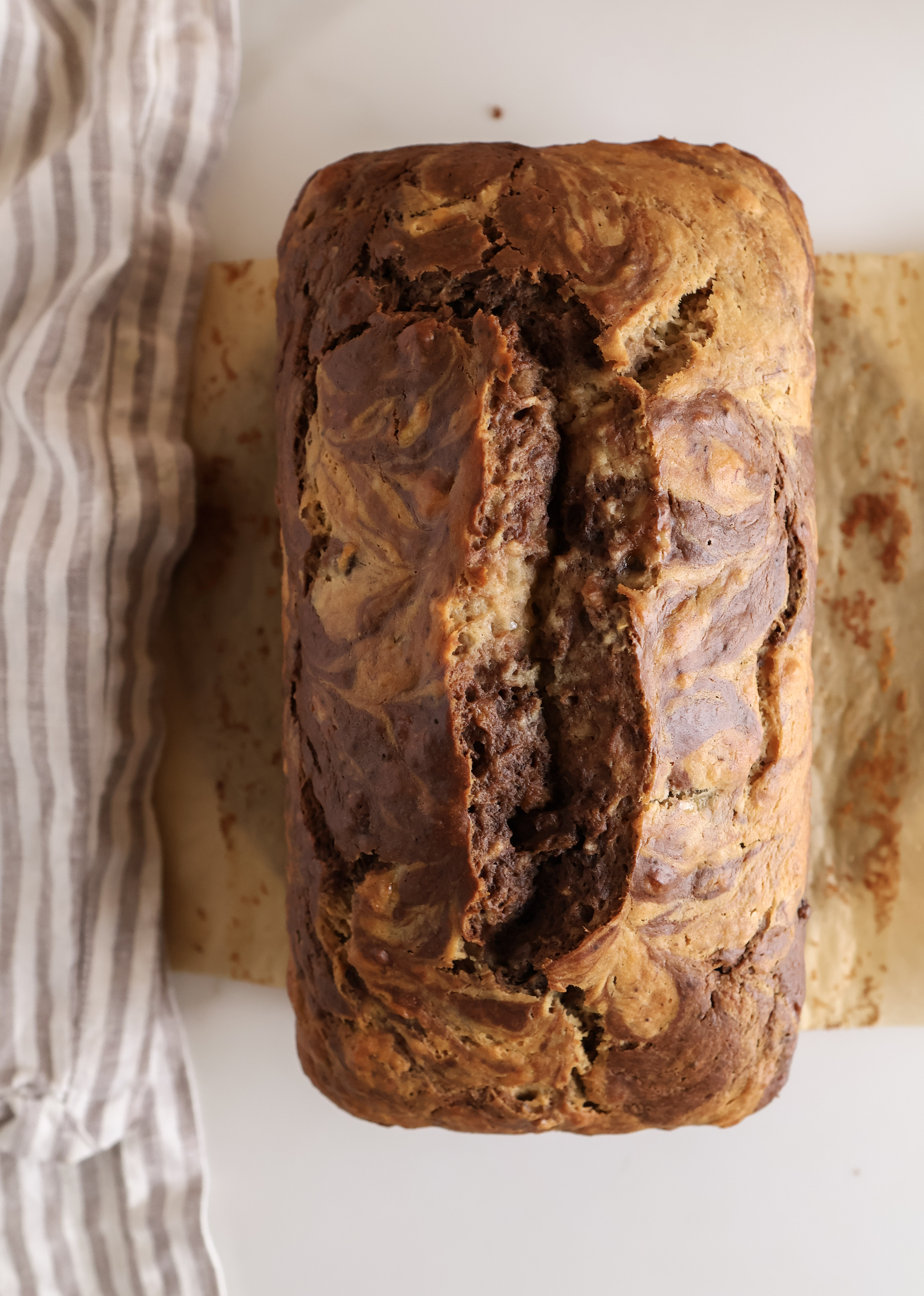 Looking down on a chocolate marbled banana bread loaf just after coming out of the oven.