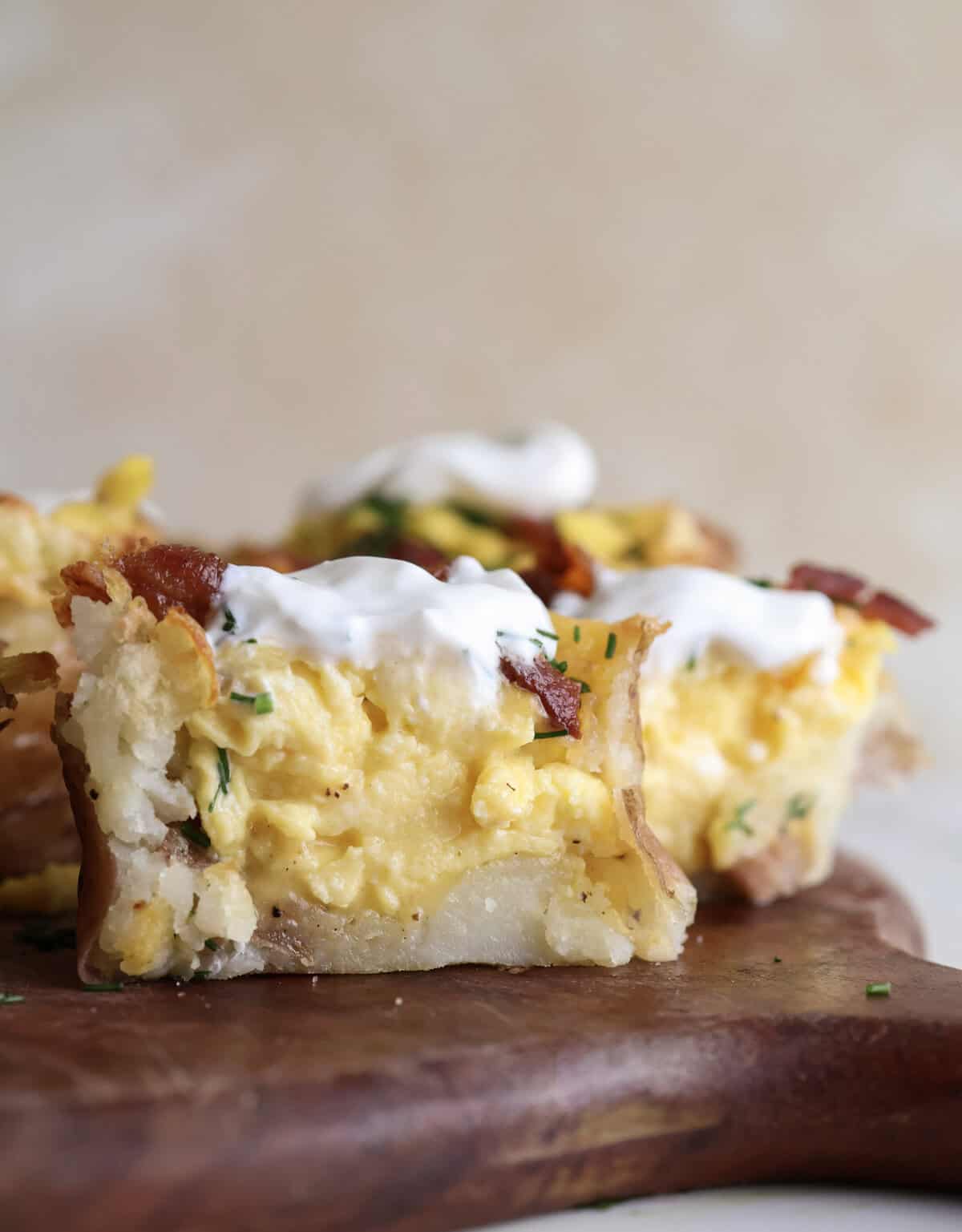 A smashed loaded potato cup cut in half showing the scrambled eggs in the center.