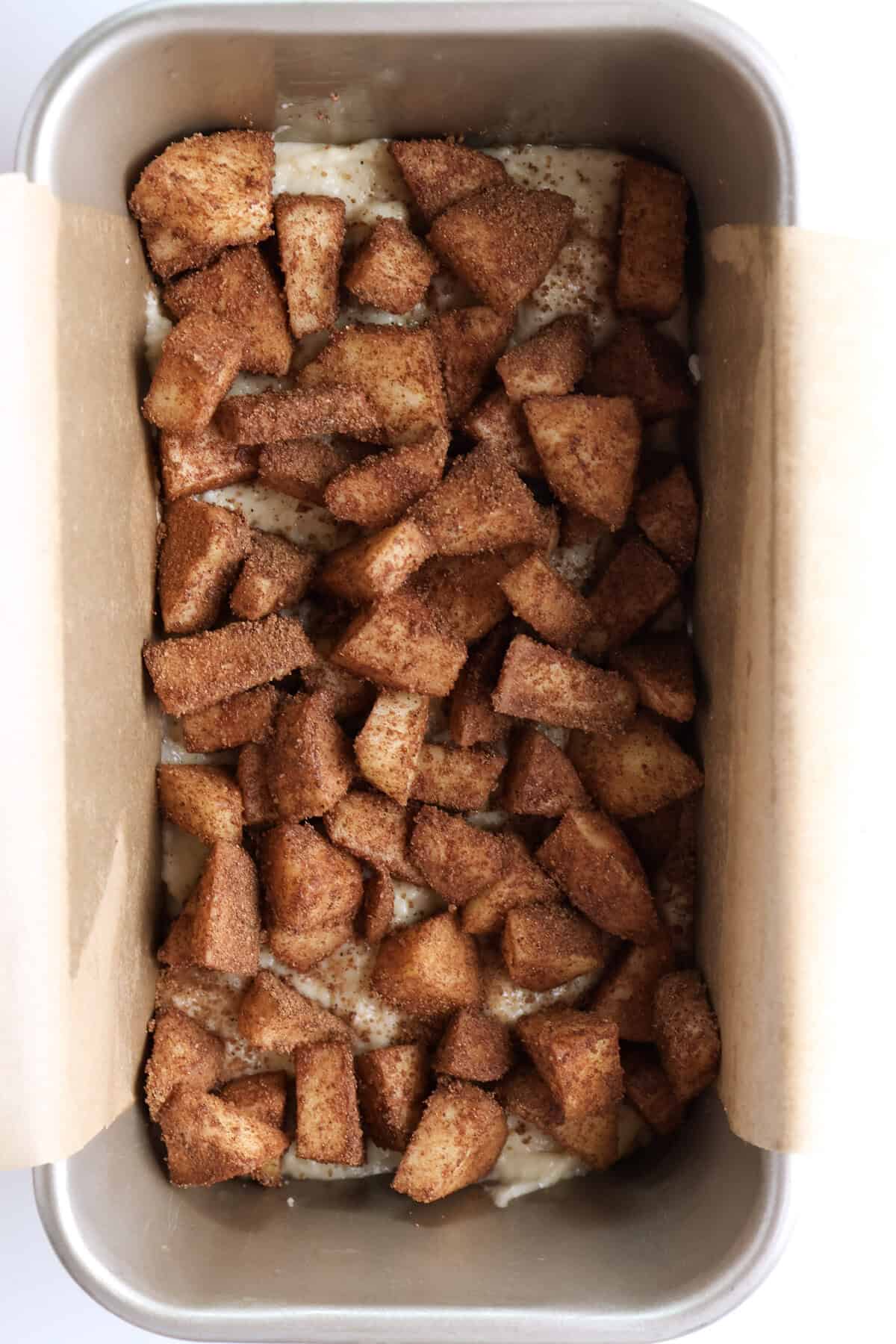 diced apples in a loaf pan over the ricotta olive oil cake batter before being baked