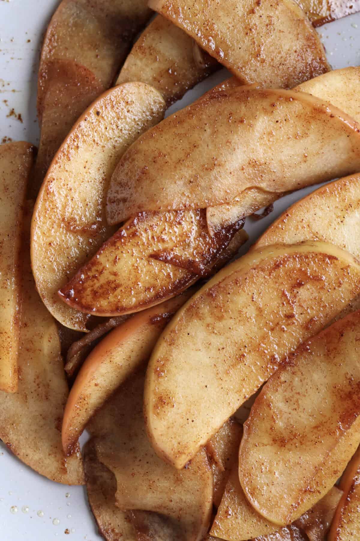 Up close of cinnamon apples sauteing in a skillet.