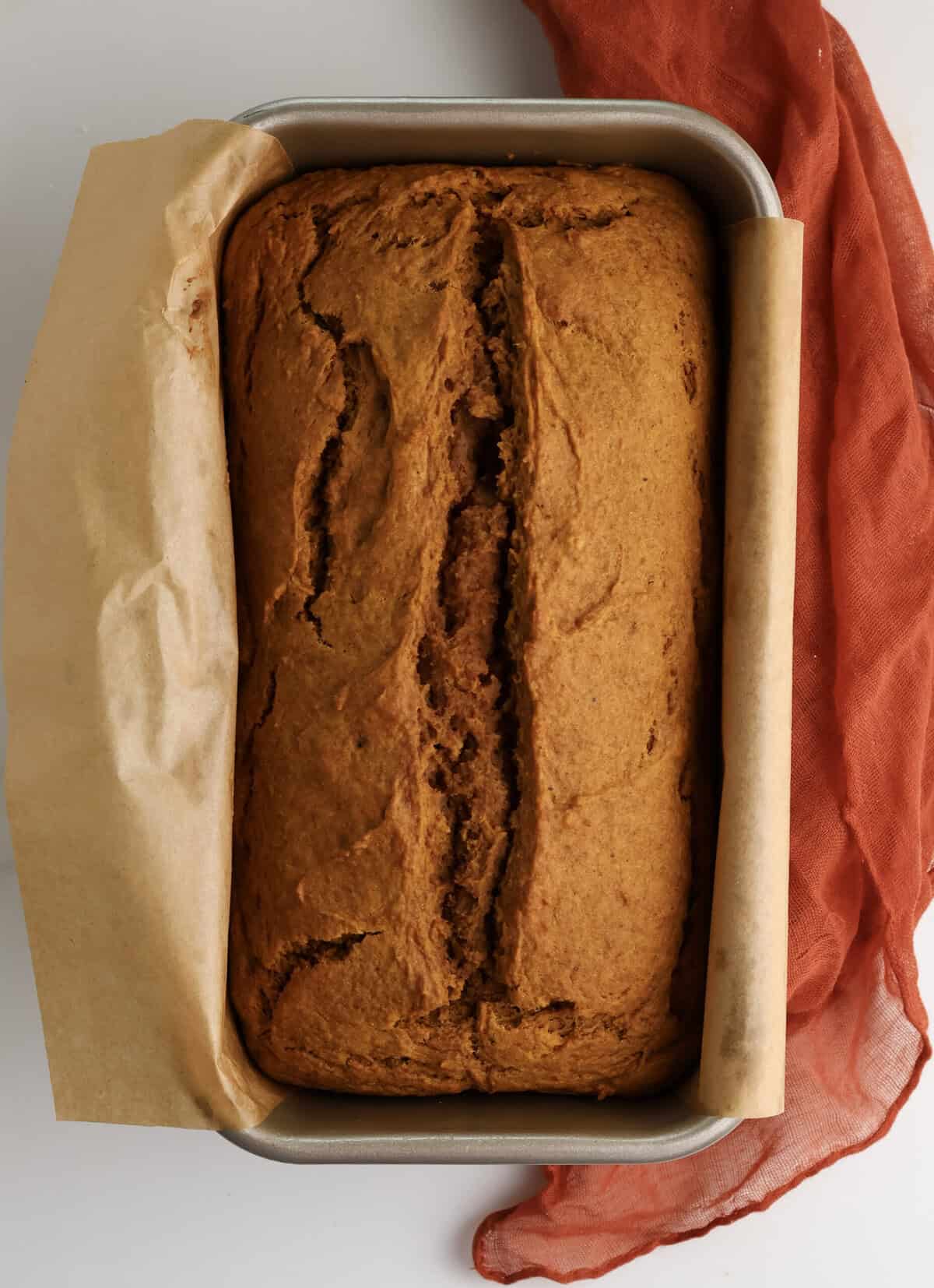 Freshly baked spiced pumpkin bread in a loaf pan.