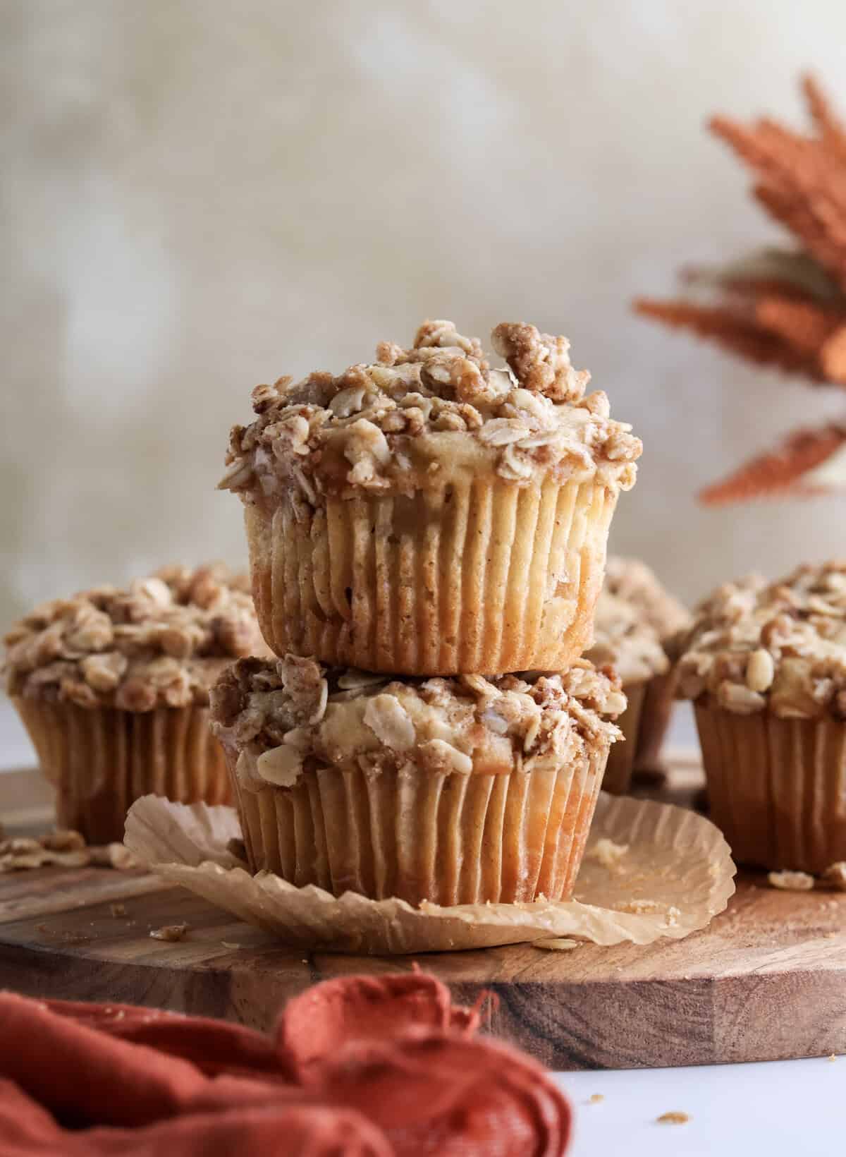 Baked cinnamon apple crisp muffins stacked on top of each other. 