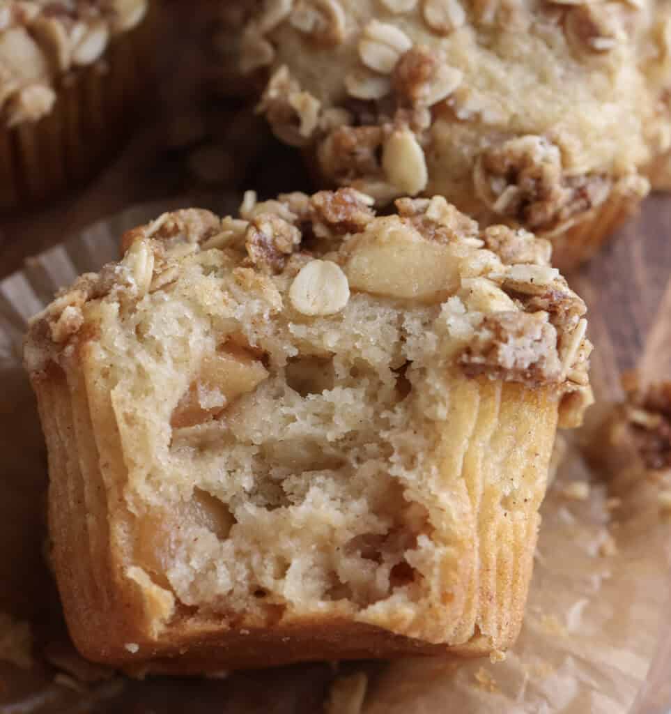 Up close of apple crisp muffin with a bite.