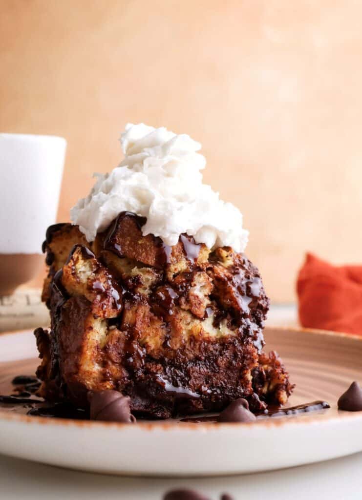 Slice of the sourdough French toast casserole with whipped cream.