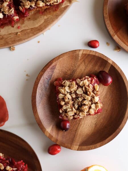 Cranberry and orange oat bars on plates.