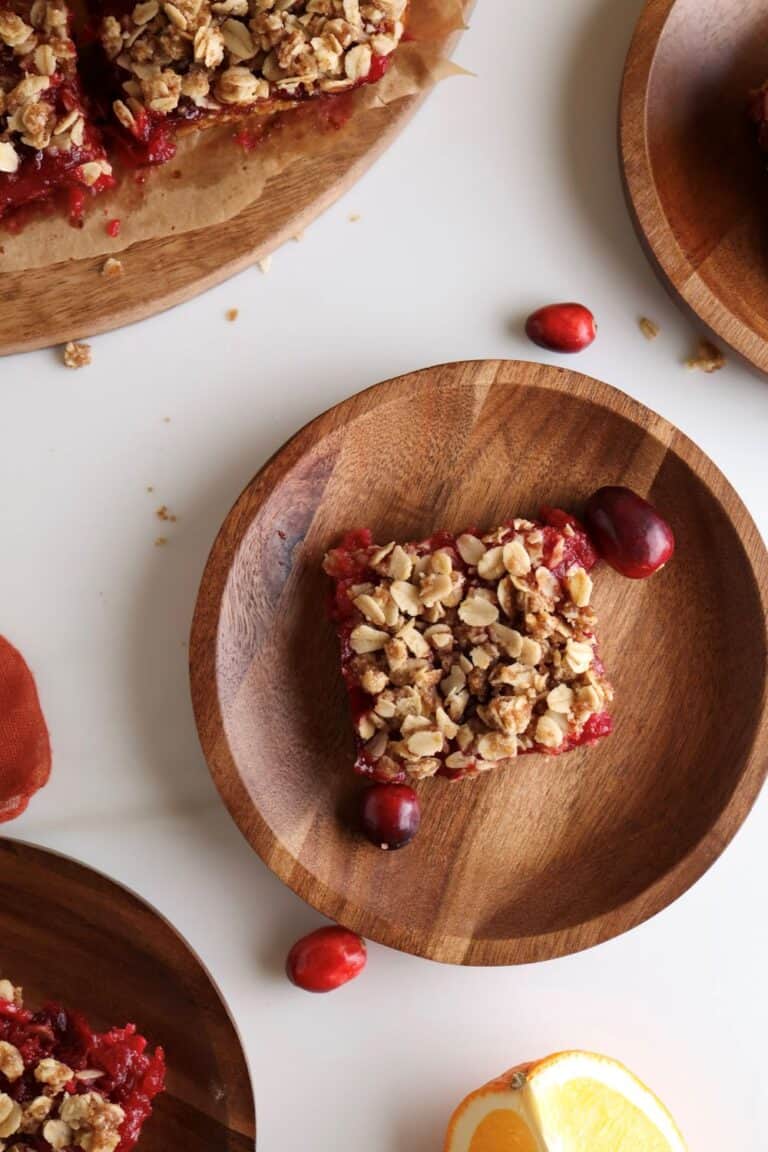 Cranberry and orange oat bars on plates.