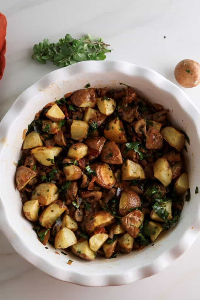 The roasted potatoes and vegetables in a baking dish for the potato breakfast bake.