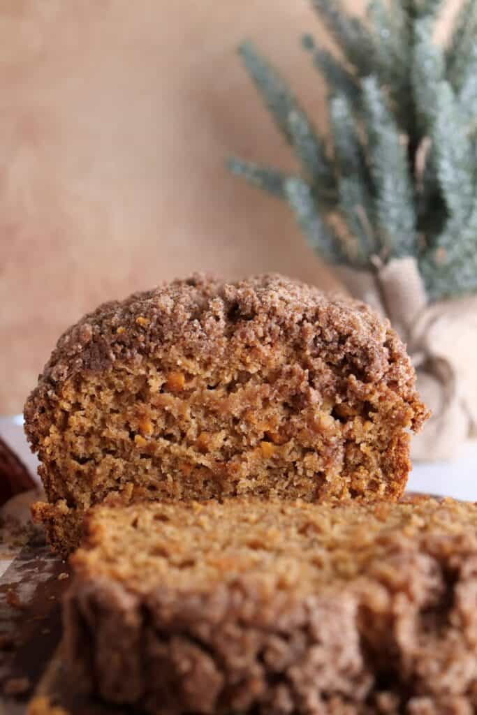 Sweet potato bread with crumble topping sliced into on a cutting board.