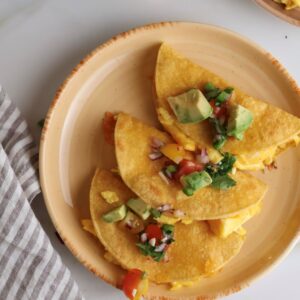 Breakfast tacos with scrambled eggs on a plate.