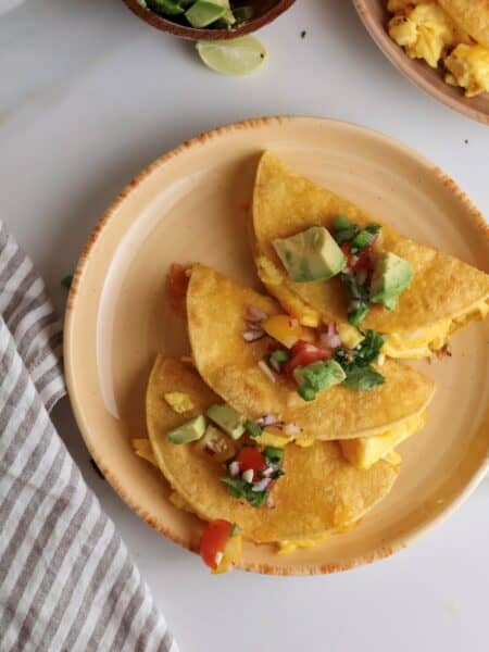 Breakfast tacos with scrambled eggs on a plate.