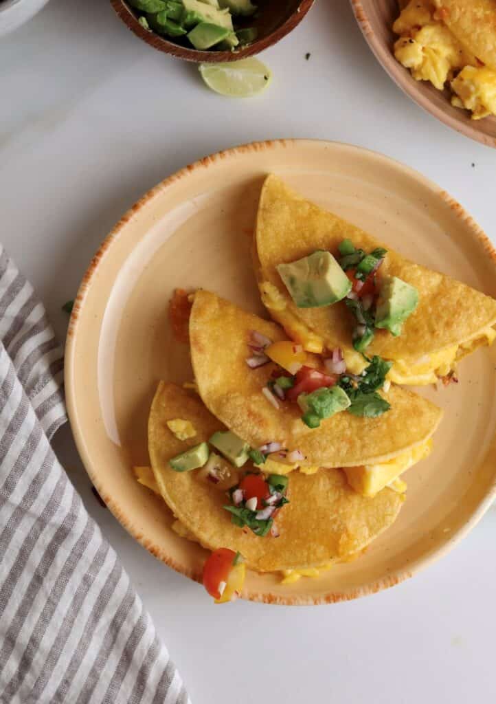 Breakfast tacos with scrambled eggs on a plate.