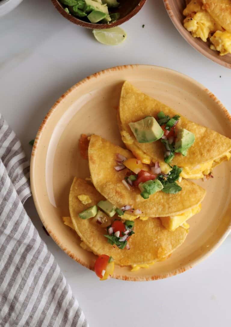 Breakfast tacos with scrambled eggs on a plate.