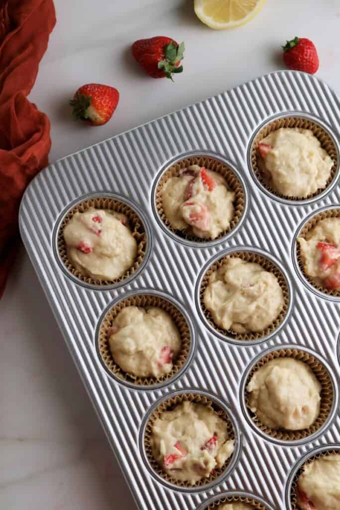Strawberry lemon muffin batter in the muffin tins.