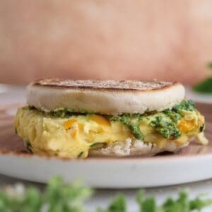 Freezer breakfast sandwich with pistachio pesto on a plate.