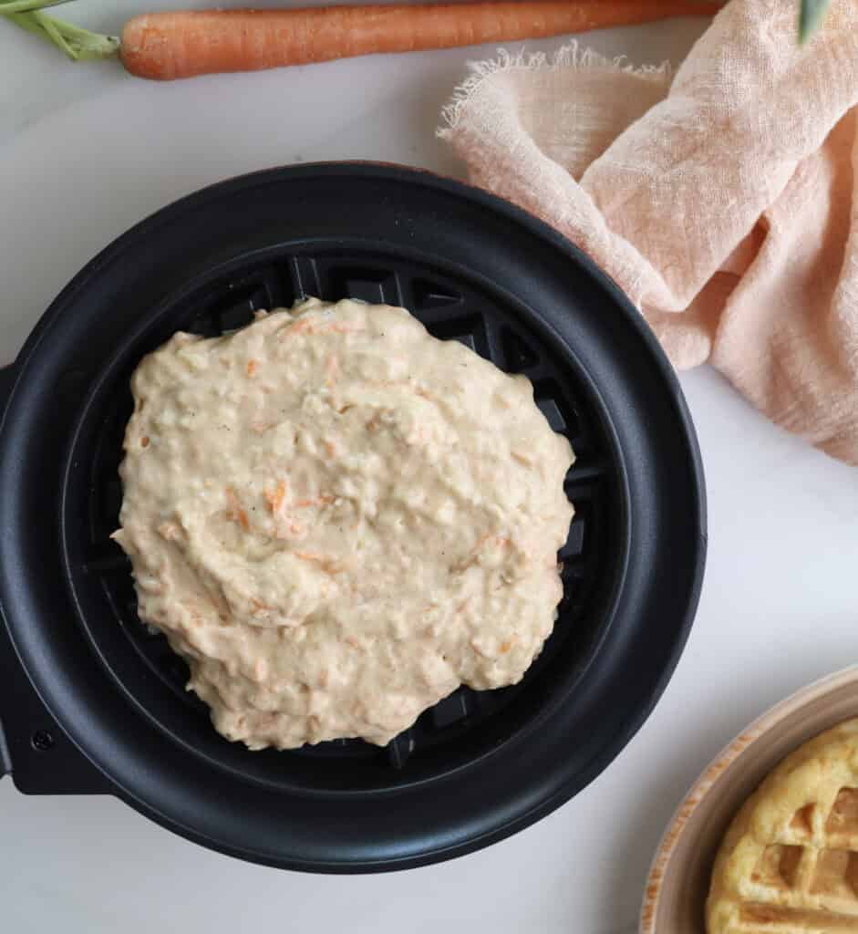 Carrot cake waffle batter in a waffle maker.
