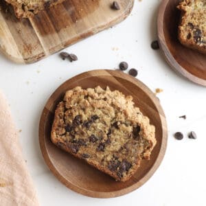 A slice of chocolate chip banana bread with crumble topping on a plate.