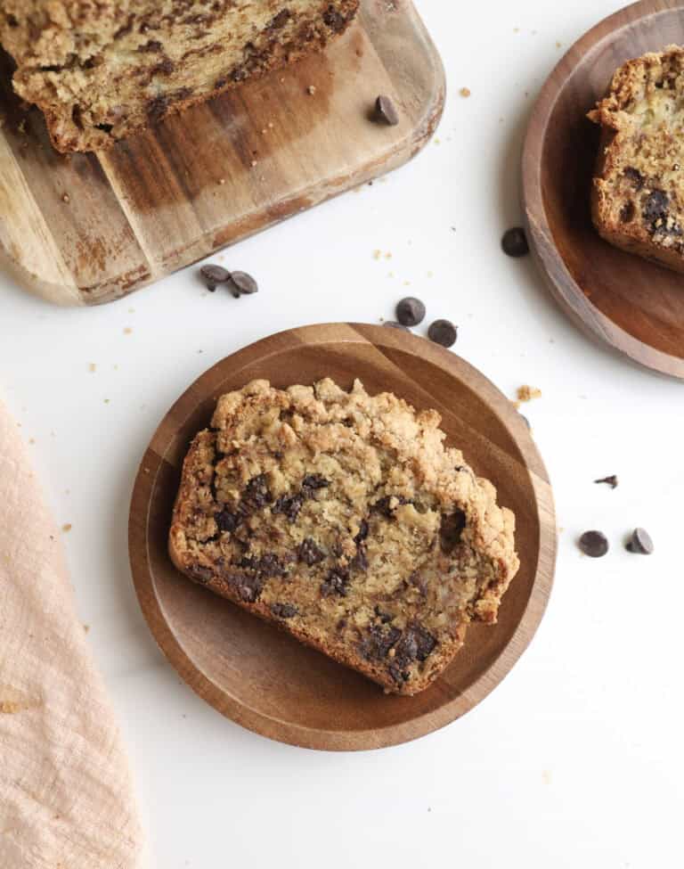 A slice of chocolate chip banana bread with crumble topping on a plate.