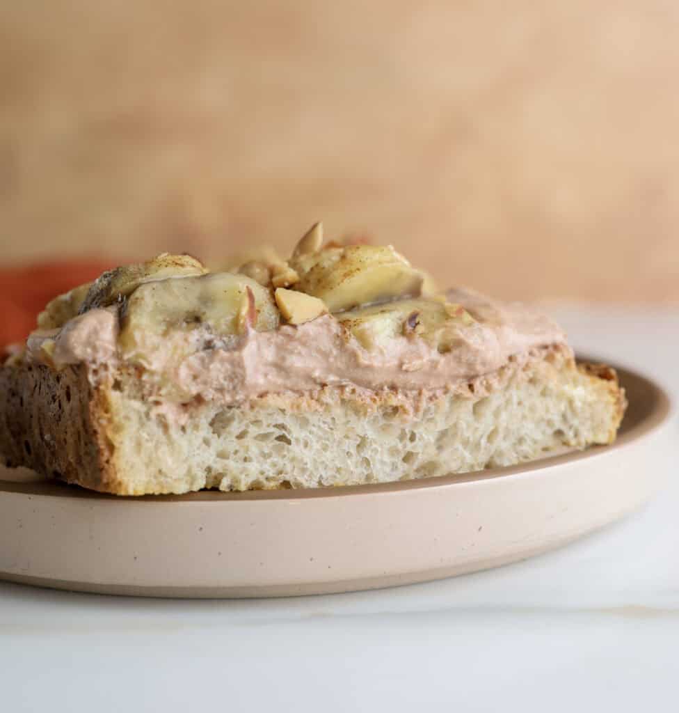 Cottage cheese chocolate toast with bananas cut in half on a plate.