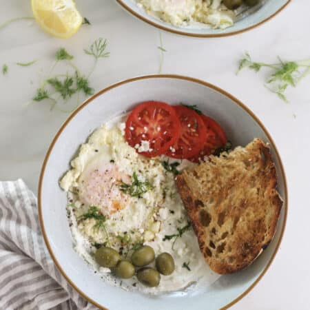 Savory Greek Yogurt Breakfast Bowls with Feta fried eggs, tomatoes, and olives.