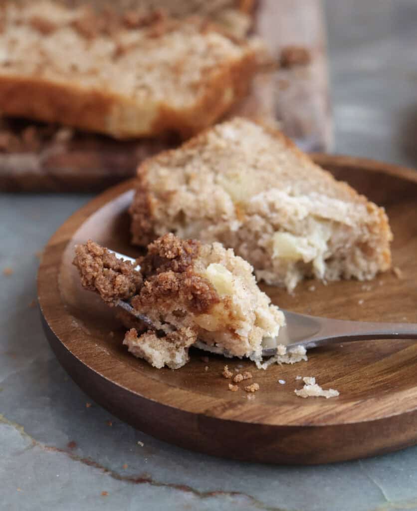 Slice of peach cobbler bread on a plate with fork.