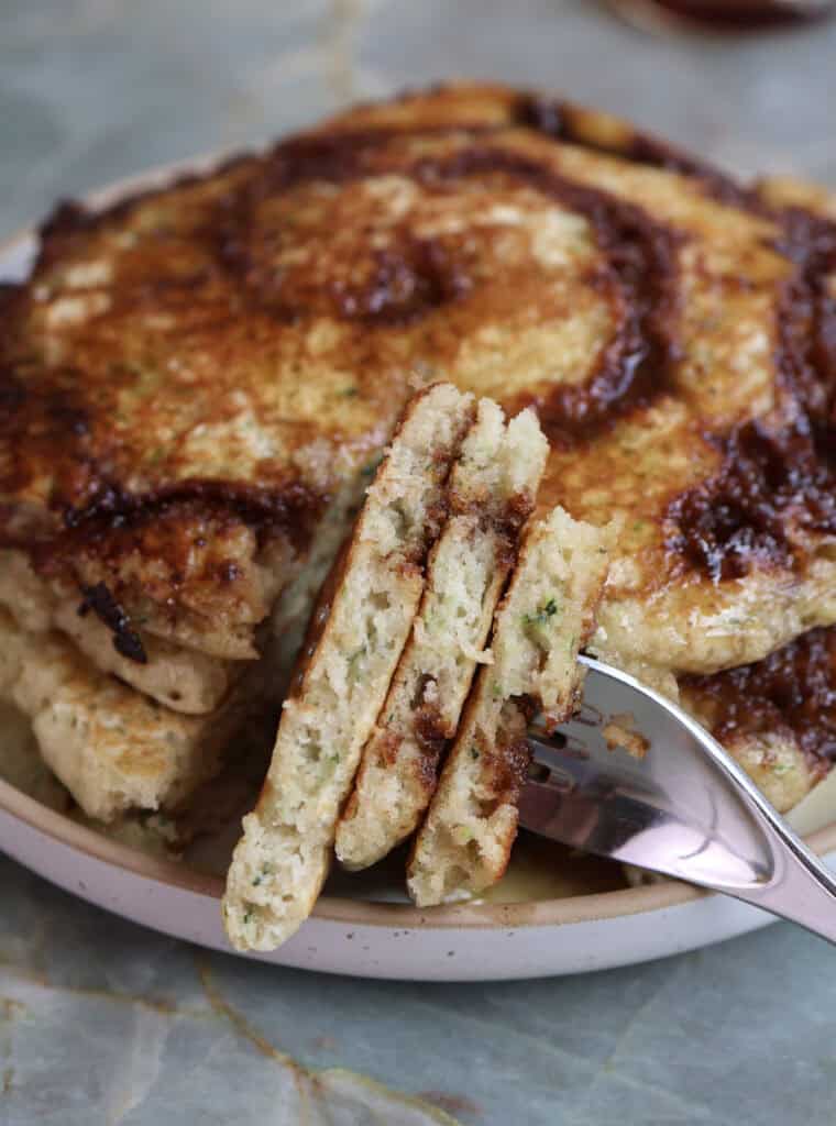 Cinnamon Roll and Zucchini buttermilk pancakes on plate with a fork. 