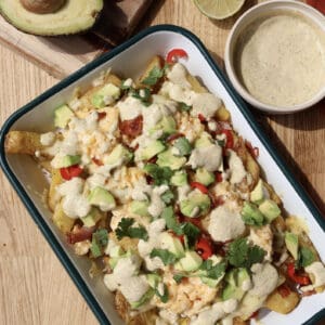 Spicy Loaded Breakfast Fries with Jalapeno aioli on serving platter.