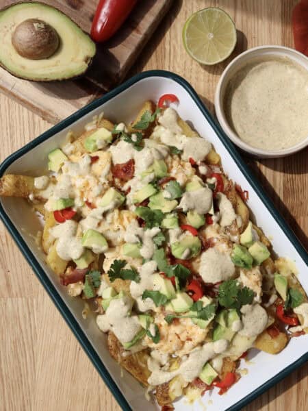 Spicy Loaded Breakfast Fries with Jalapeno aioli on serving platter.