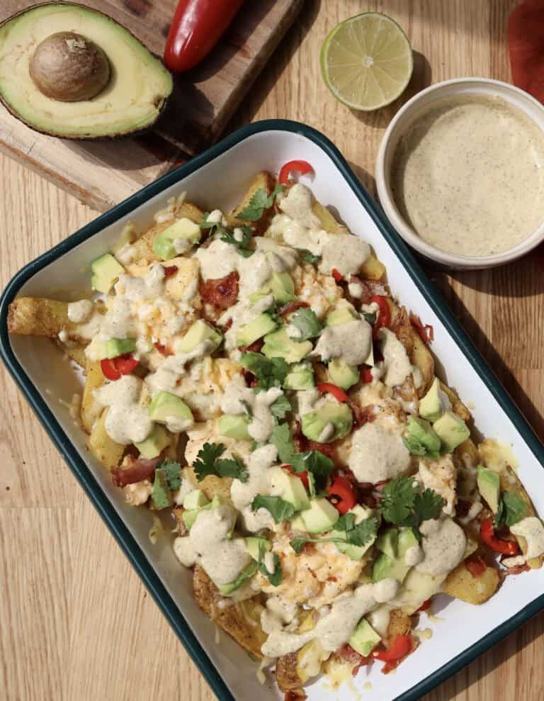Spicy Loaded Breakfast Fries with Jalapeno aioli on serving platter.