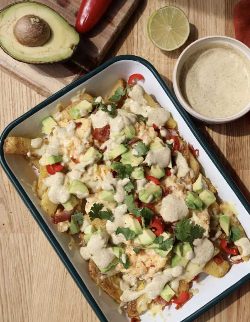 Spicy Loaded Breakfast Fries with Jalapeno aioli on serving platter.