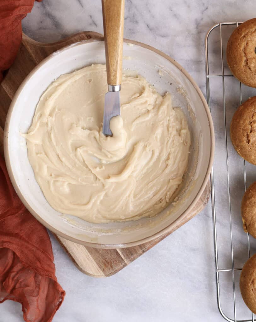 Maple icing for the baked pumpkin donuts in a mixing bowl.