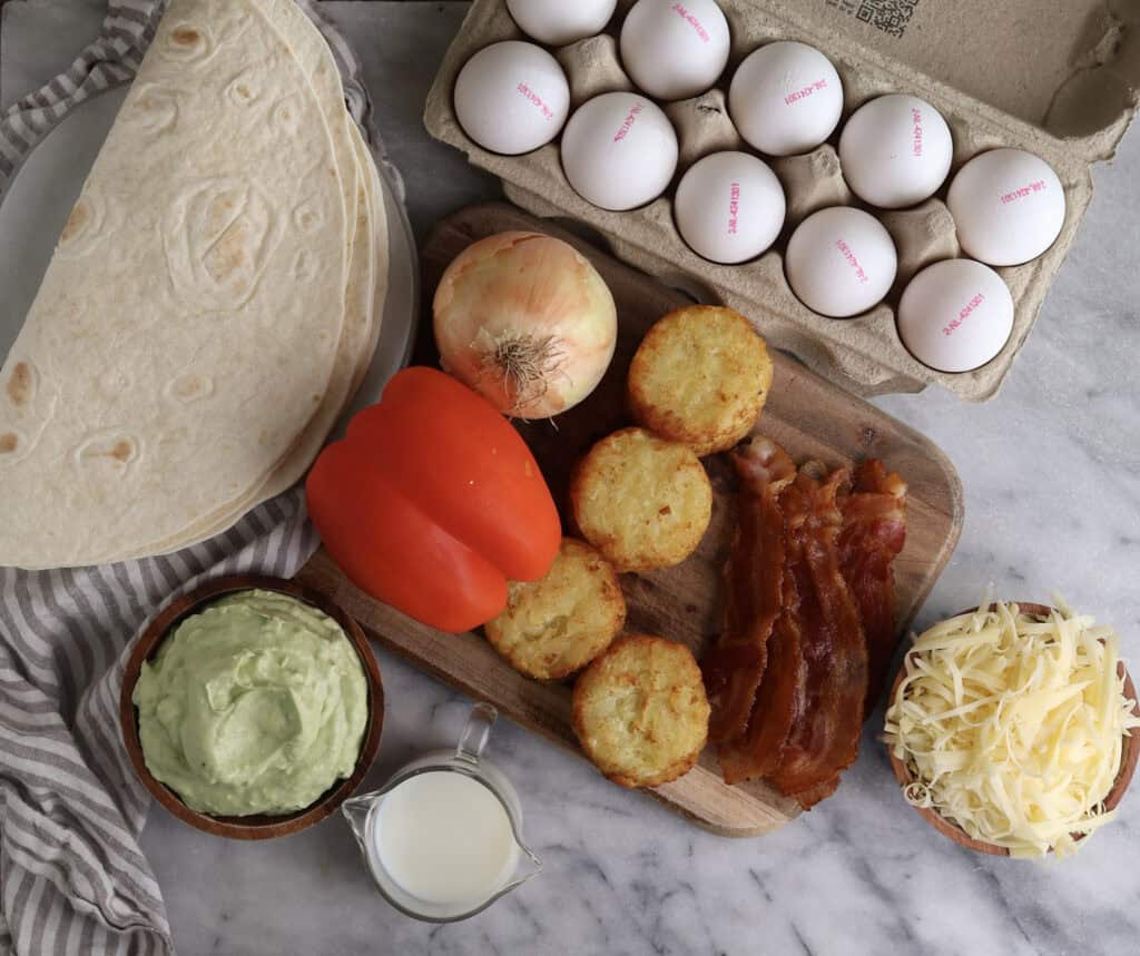 The ingredients for the breakfast burritos with hashbrowns and avocado crema on the counter.