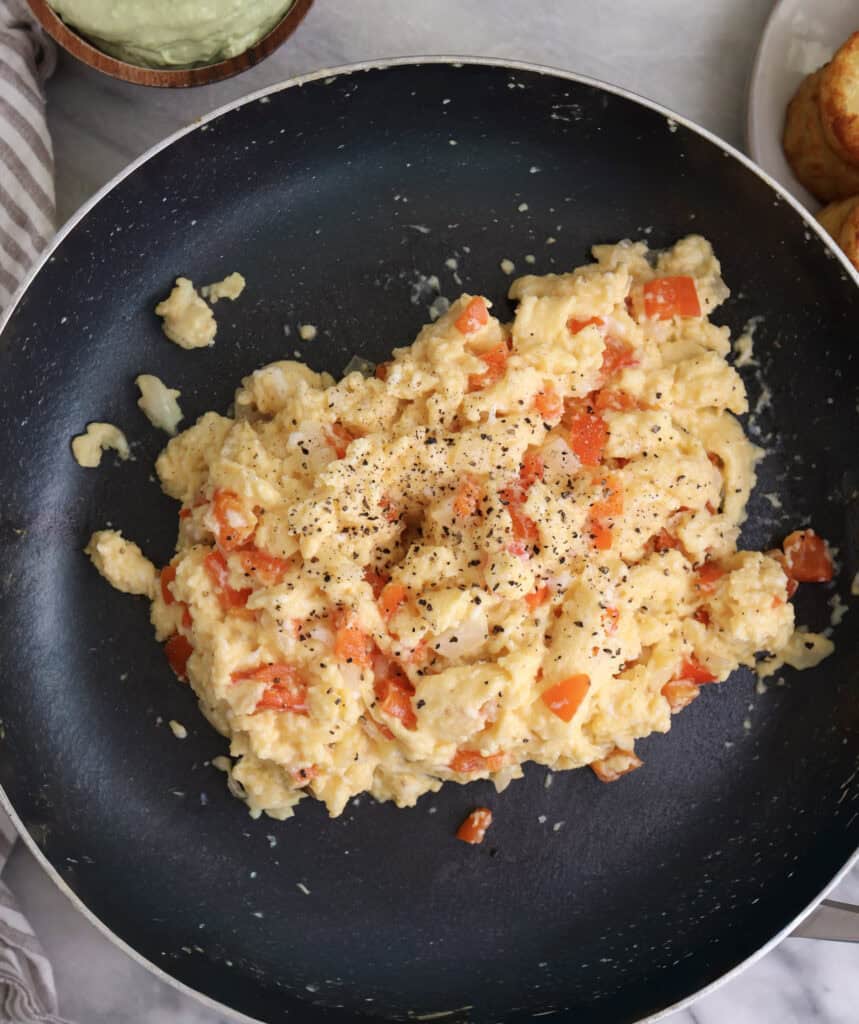 Scrambled eggs with veggies in skillet for the breakfast burritos.