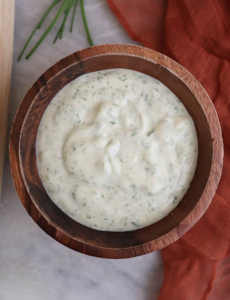 Up close of the garlic chive mayo in a wood bowl.
