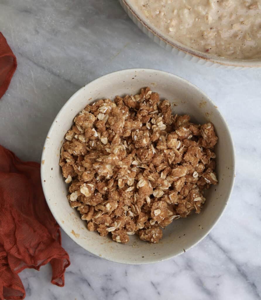 The oat streusel in a bowl before topping the apple muffins.