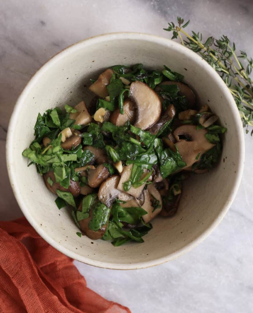 The mushrooms, spinach and thyme in a bowl ready to go into the egg wrap.