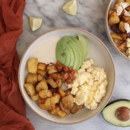 Breakfast Potato Bowl plated with the chipotle sauce and sliced avocado.