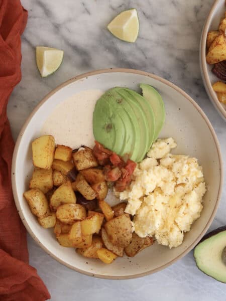 Breakfast Potato Bowl plated with the chipotle sauce and sliced avocado.