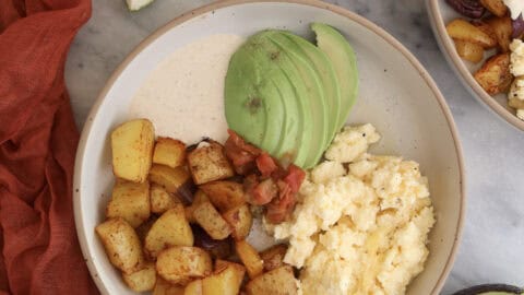 Breakfast Potato Bowl plated with the chipotle sauce and sliced avocado.