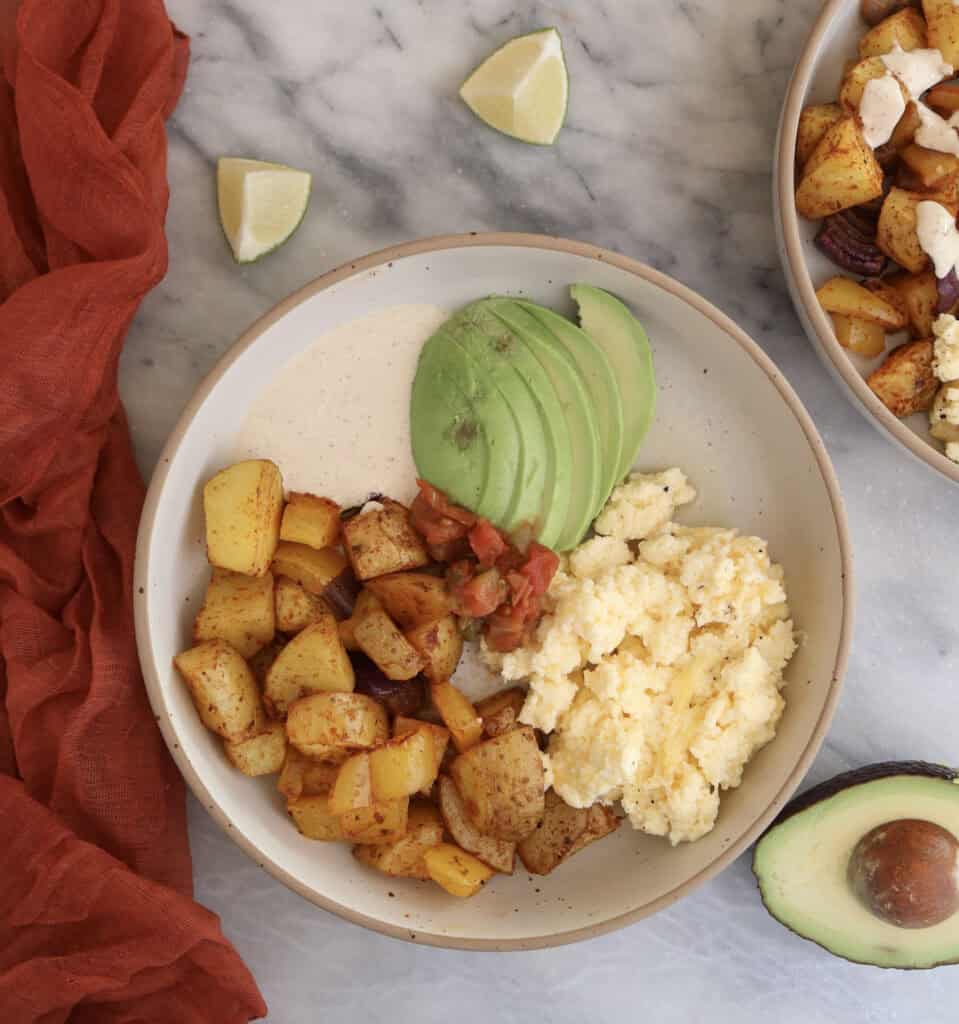Breakfast Potato Bowl plated with the chipotle sauce and sliced avocado.