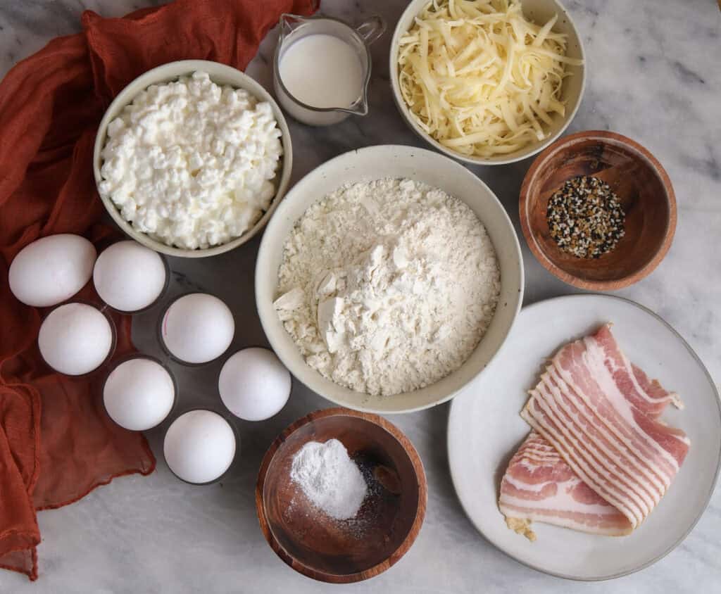 The ingredients needed to make the breakfast pockets with cottage cheese dough, bacon, eggs and cheese.