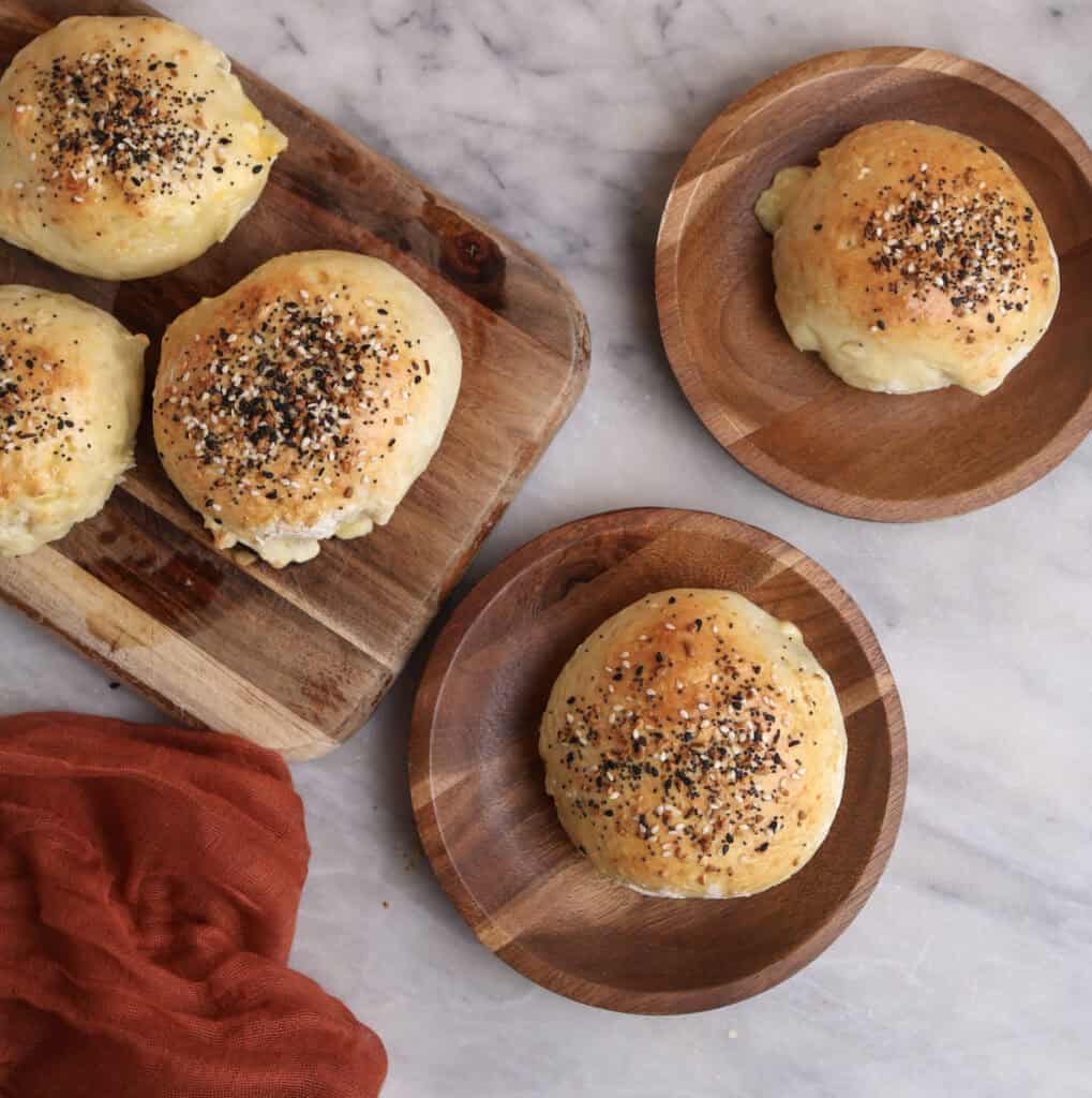 Breakfast pockets on a wood plates, showing the golden brown tops with everything bagel seasonings.